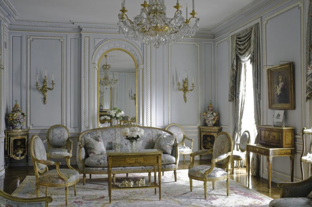 A room with a couch chairs and a chandelier